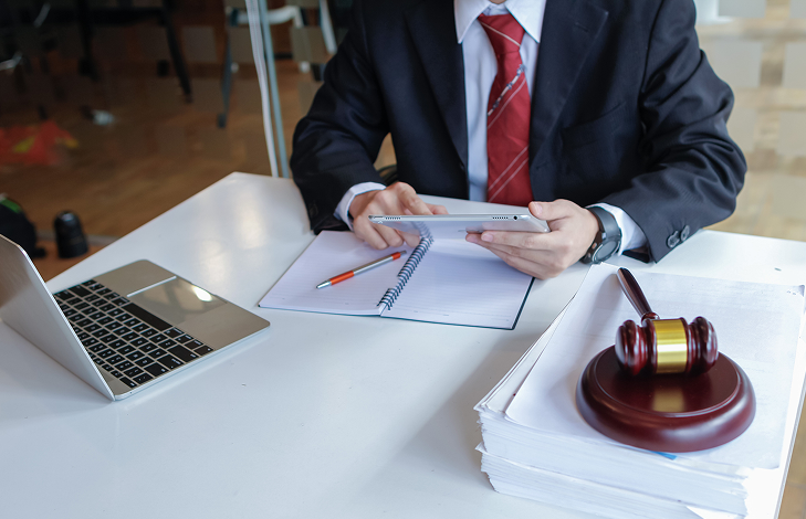 Man in suit with tablet and gavel.